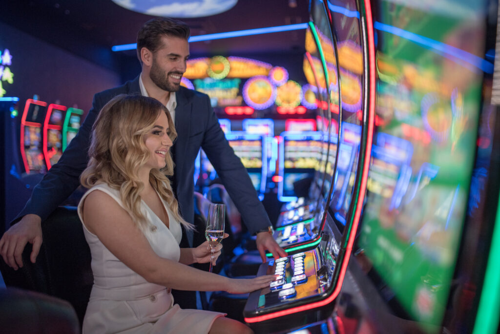 young happy couple gambling at the slot machines in Cripple Creek and drinking wine