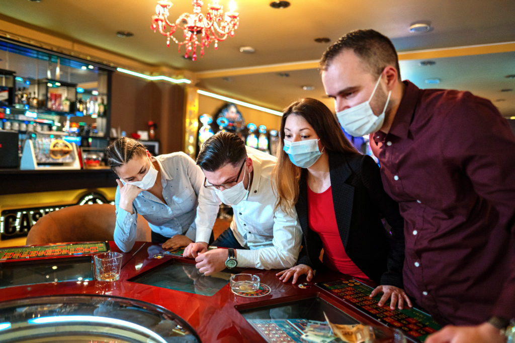 People with face protection mask playing roulette in Casino