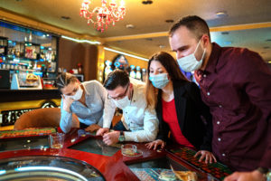 People with face protection mask playing roulette in Casino