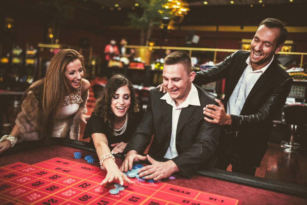 4 friends having fun winning at a roulette table and enjoying roulette payouts
