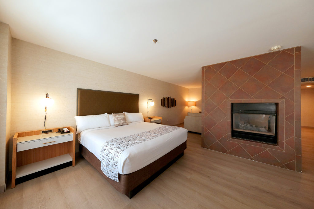 Our Deluxe Suite Featuring A King Bed With Fireplace In The Room