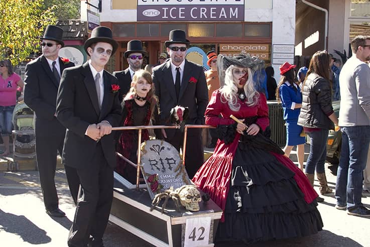 A racing team dressed in Halloween garb posing with their coffin before coffin races in Manitou Springs