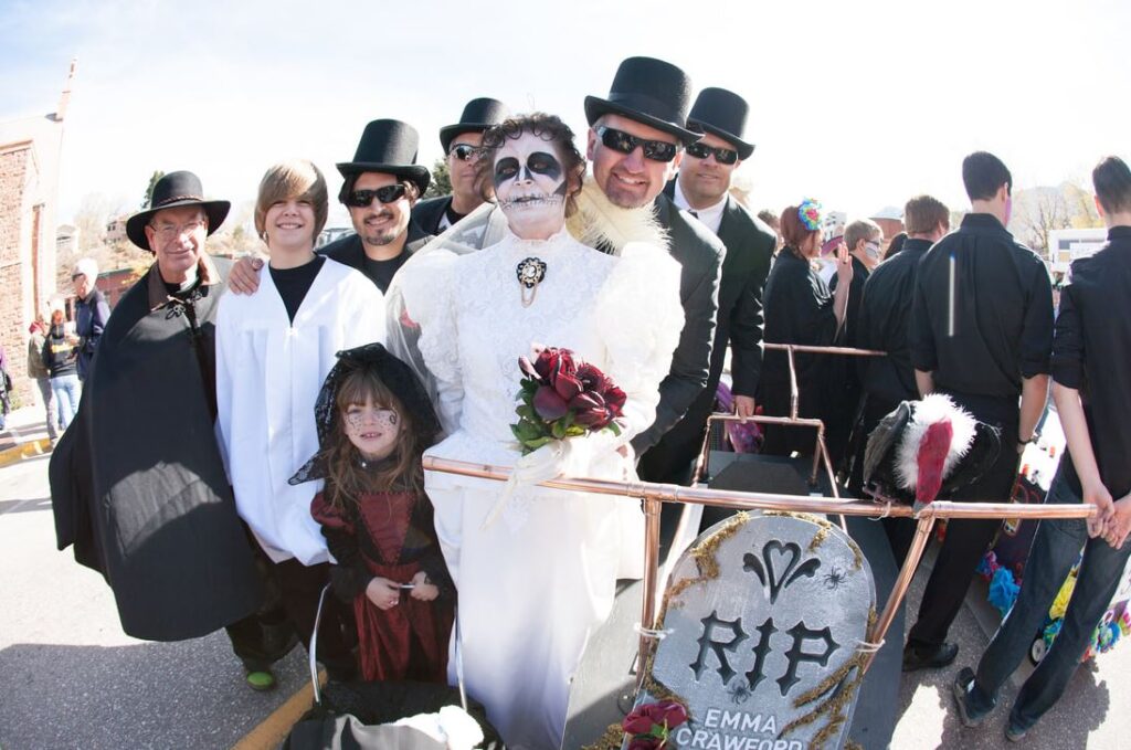 A group in costumes stand in a coffin built for racing at the Emma Crawford Festival in Manitou Springs, Co