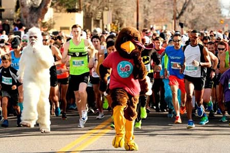 A person dressed as a turkey leads many race participants in the Thanksgiving getaway turkey trot.