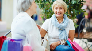 Two Women Sitting On A Bench Making Conversation