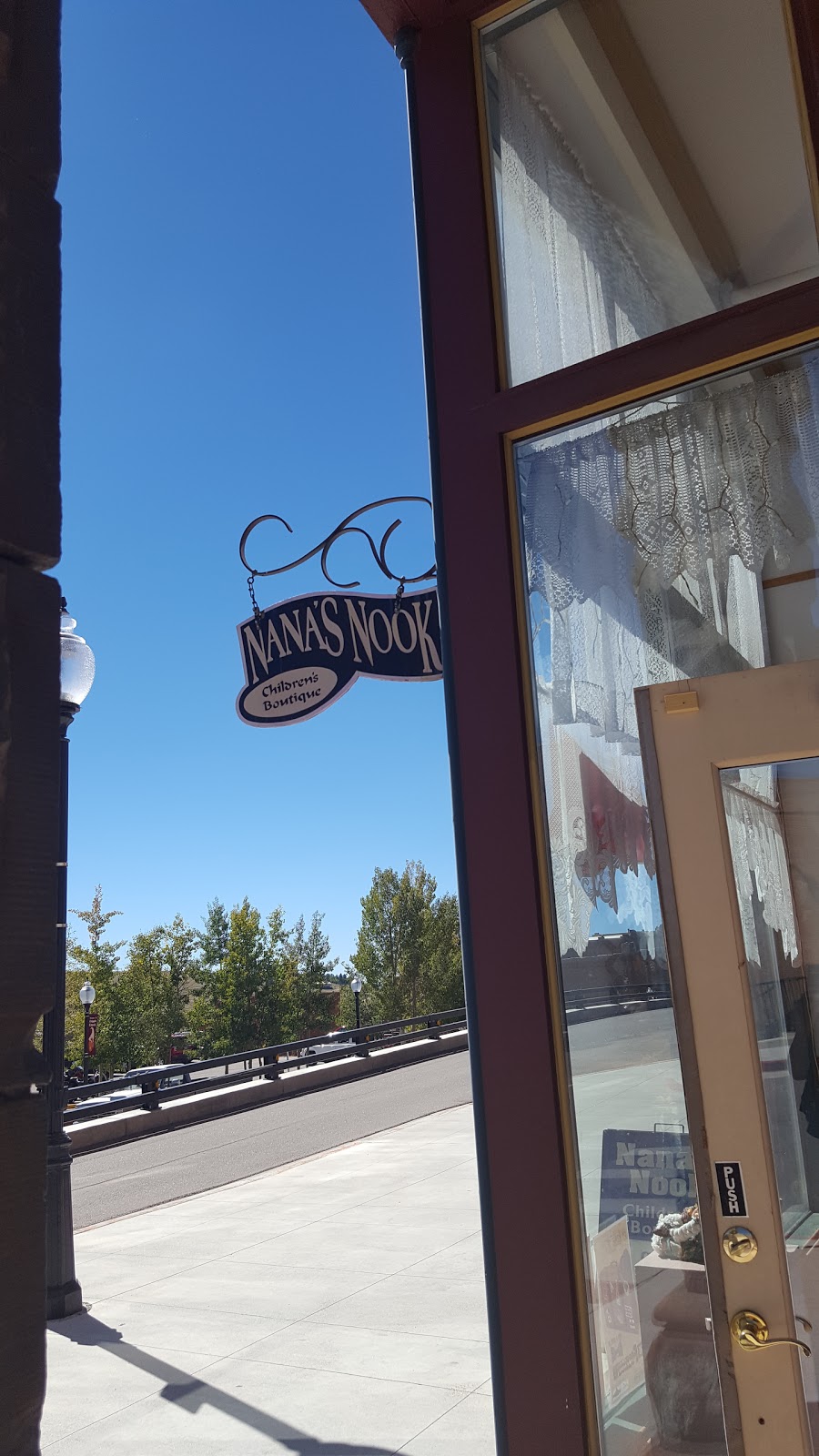 A picture of the store sign of "Nana's Nook" hanging outside the shop door