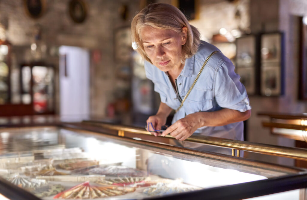 woman visitor in the historical museum looking at art object