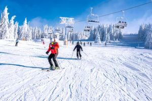 People enjoying skiing and snowboarding in mountain ski resort w