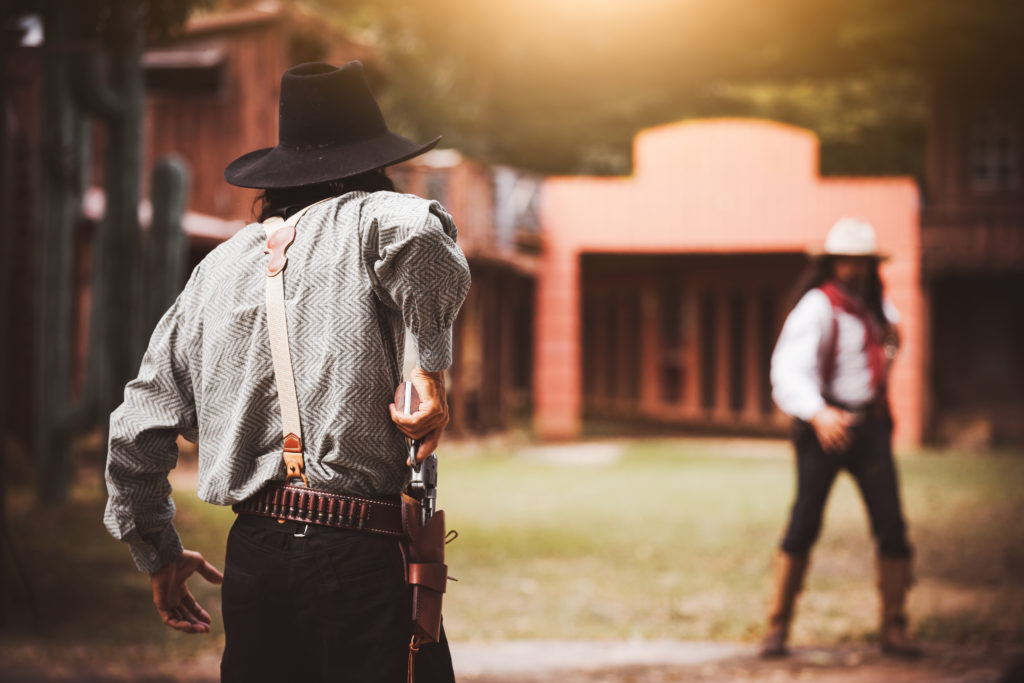 Backside view of cowboy while standing gun prepares on gunfight