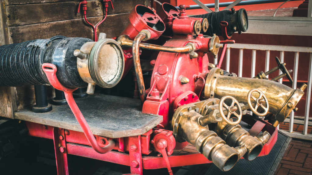 Old red fire truck parked old garage in Malaysia. Old vintage fire truck concept.