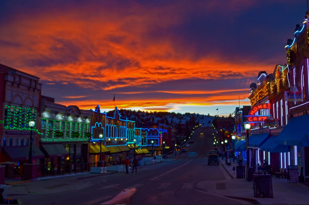 Downtown Cripple Creek at sunset with the neon lights on all the buildings lit