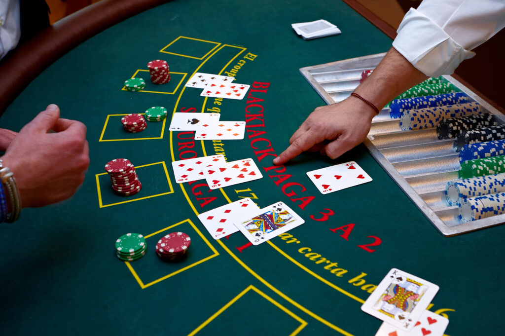 A close up of a blackjack dealer's hands in a casino.