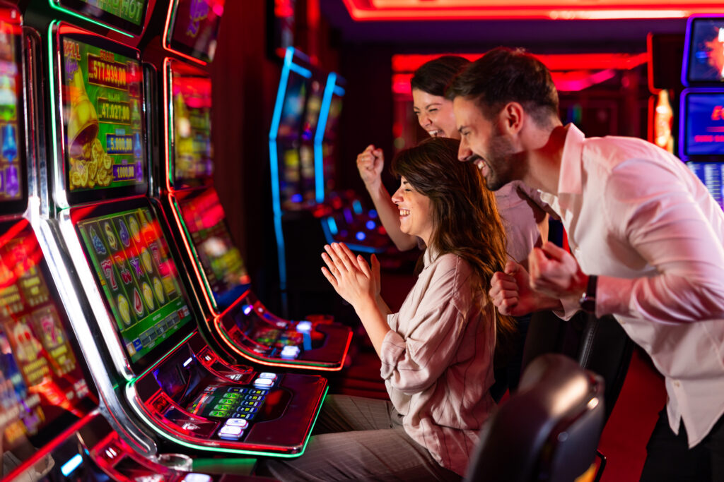 Friends Celebrating Success at Casino Slot Machines With Vibrant Lights